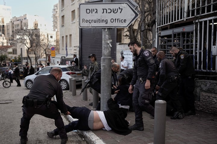 La policía forcejea con un hombre ultraortodoxo durante una marcha en Jerusalén días atrás para exigir el reclutamiento obligatorio para las Fuerzas Armadas. Foto: AP