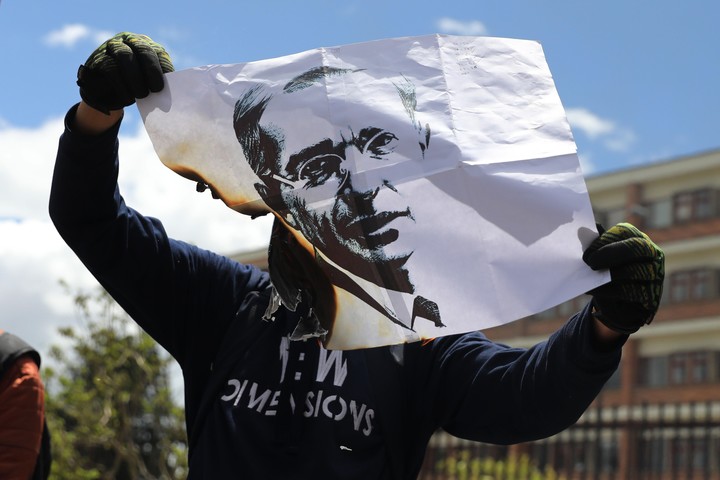 Un manifestante quema un cartel con la imagen del expresidente colombiano Álvaro Uribe, en el 2020. Foto EFE