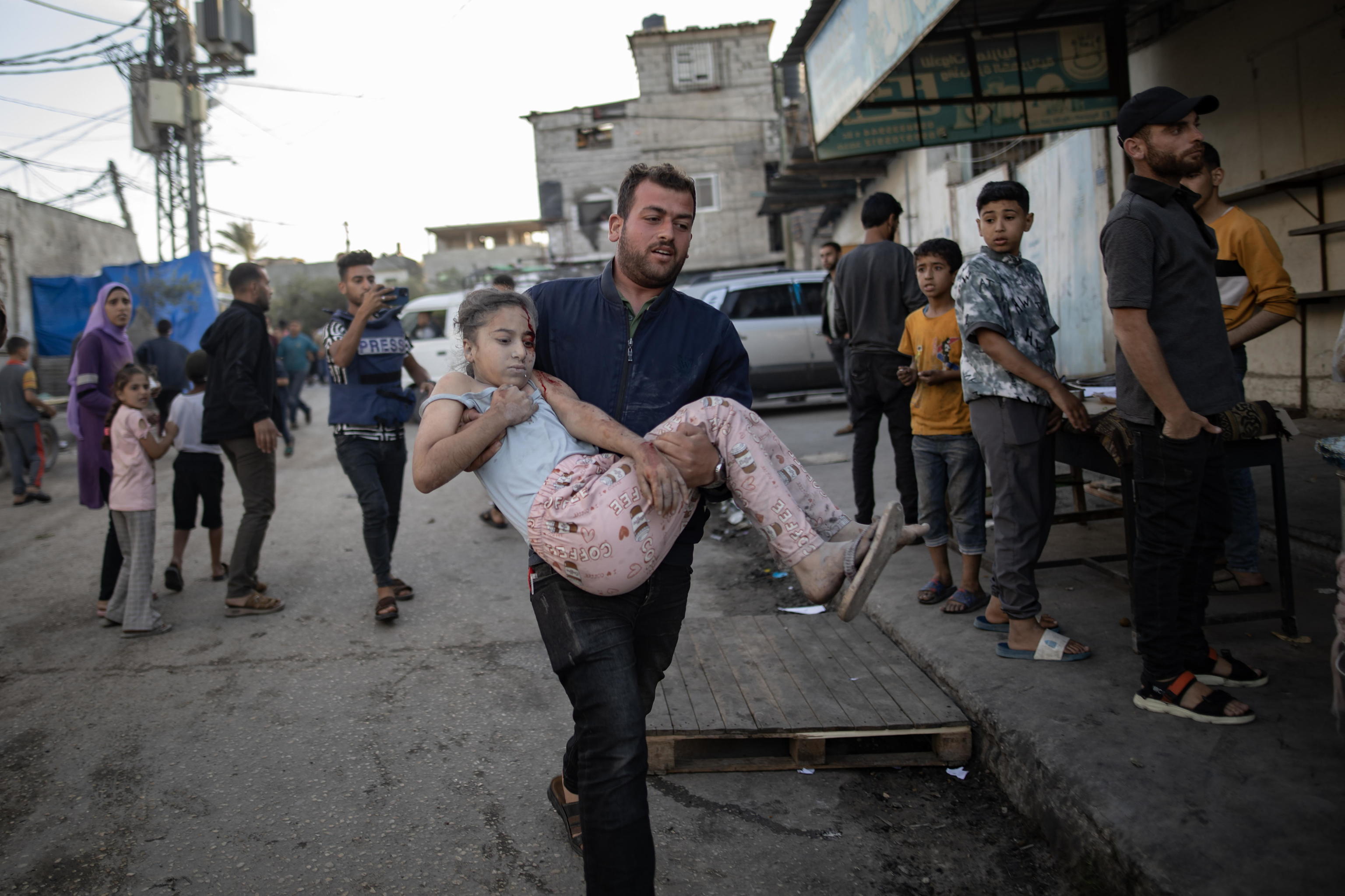 Un hombre lleva en brazos a una niña palestino herido en Rafah.